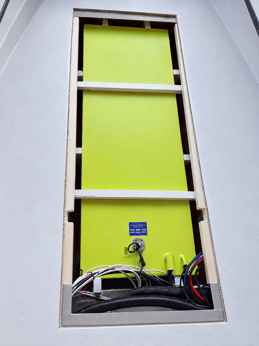 Boat fuel tanks installed in an opened fiberglass compartment with fuel lines, hoses, and wiring connected